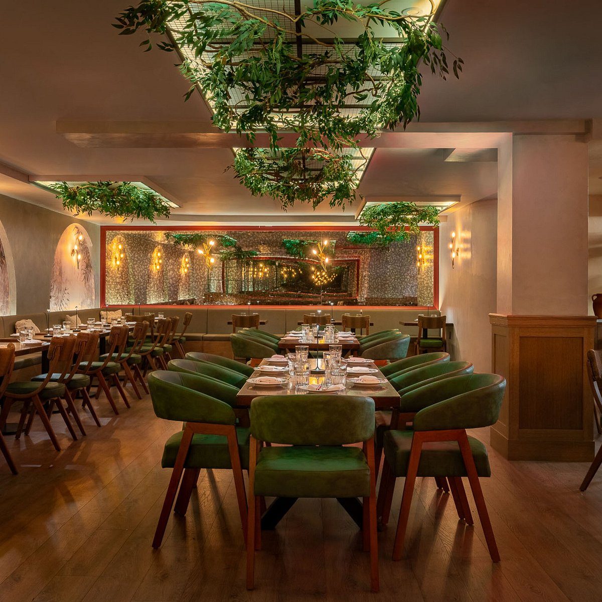 Anémi's dining room: green chairs, wood tables, olive branches hanging from the ceiling